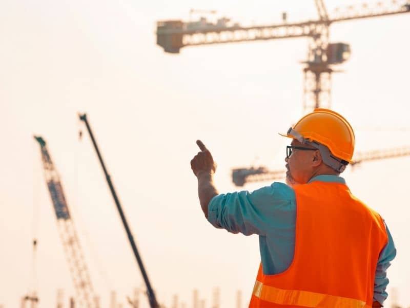 Construction professional supervising a large development project and planning future site improvements.