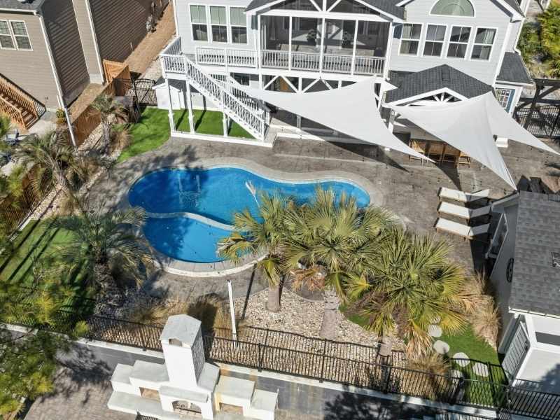 Integrated Dallas backyard featuring a pool, shade structures, landscaped areas, and connected outdoor living spaces.